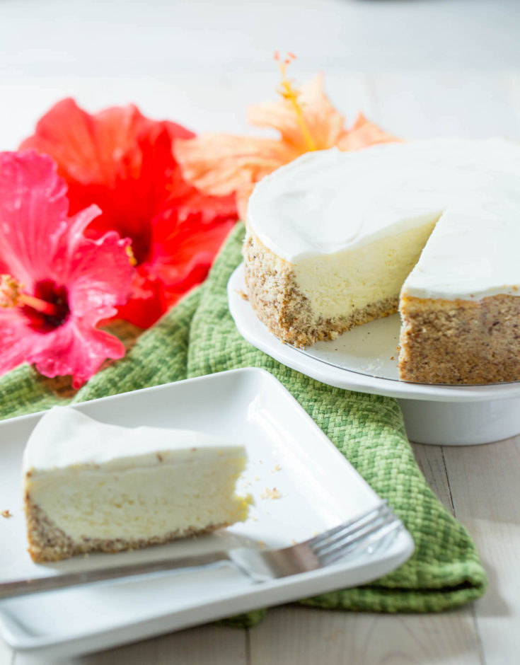 Picture of a keto cheesecake from the front with red and orange flowers