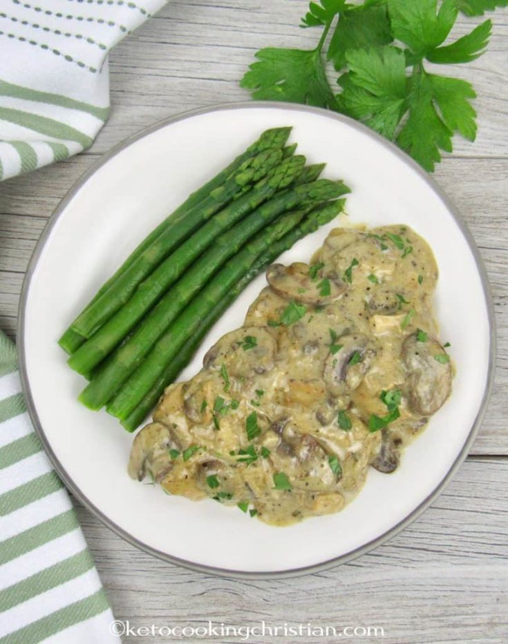 image of chicken marsala with asparagus on a white plate