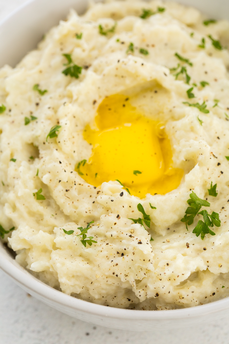 close up image of Instant Pot Mashed Cauliflower with butter and parsley 