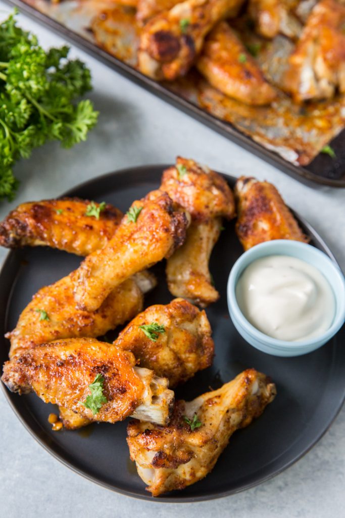 keto chicken wings on a plate with ranch topped with parsley 