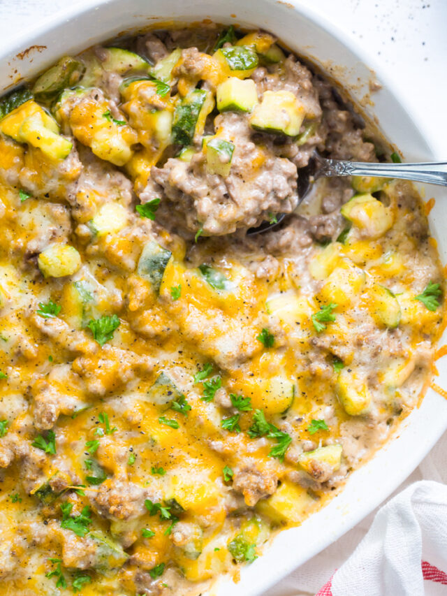 zucchini ground beef casserole in a white dish with a spoon