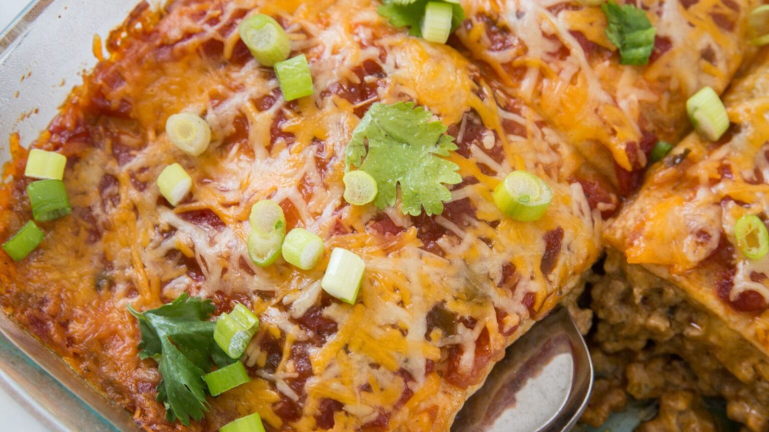 Easy Keto Mexican Casserole in a casserole dish with cilantro, green onion, and a spatula.