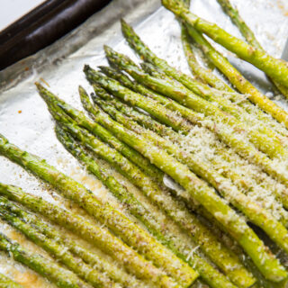 roasted garlic parmesan asparagus on a cookie sheet with aluminum foil