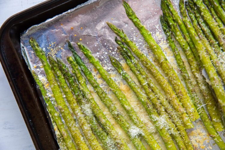 roasted garlic parmesan asparagus on a cookie sheet with aluminum foil
