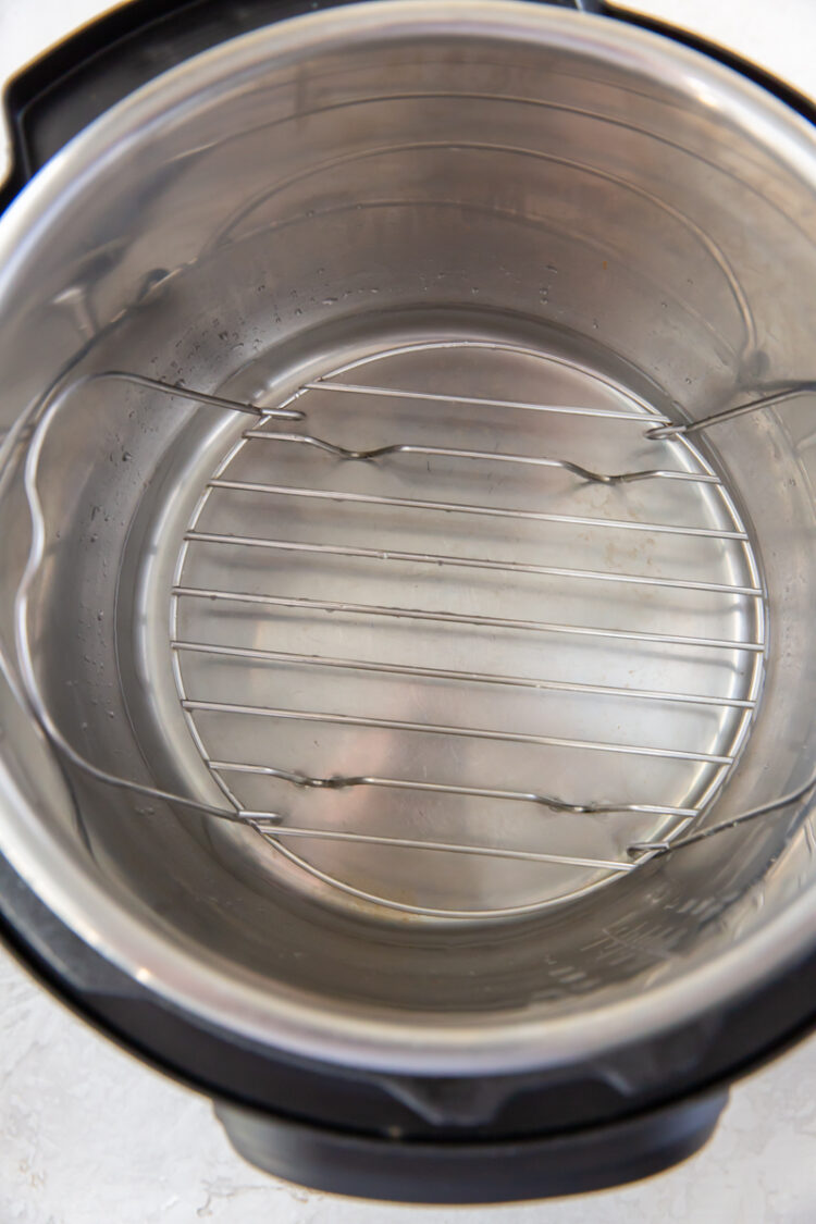 the inside of an instant pot with a trivet and water