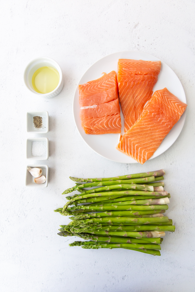 salmon on a white plate, asparagus, oil and spices