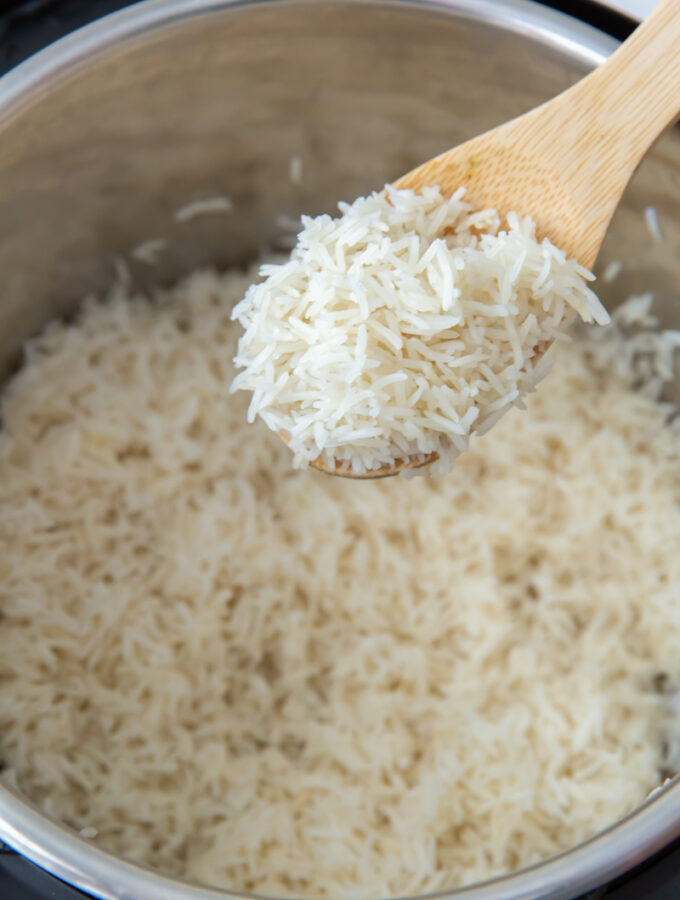a wooden spoon with a spoonful of basmati rice