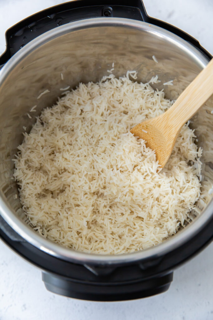 fluffing basmati rice with a wooden spoon