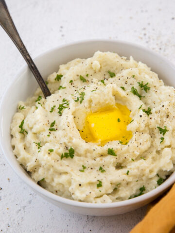 A bowl of mashed cauliflower with an egg in it.