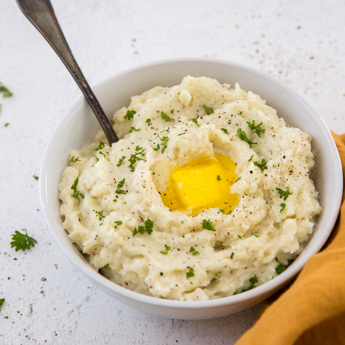 A bowl of mashed cauliflower with an egg in it.