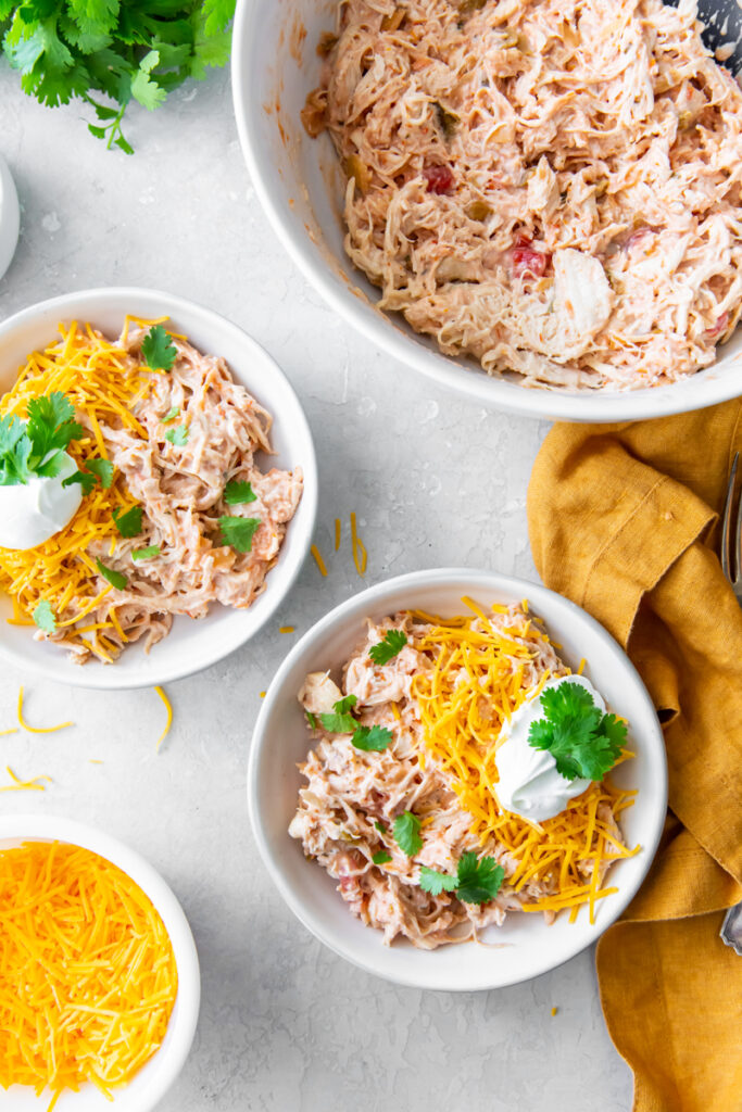 creamy salsa chicken recipe topped with shredded cheese, sour cream and cilantro
