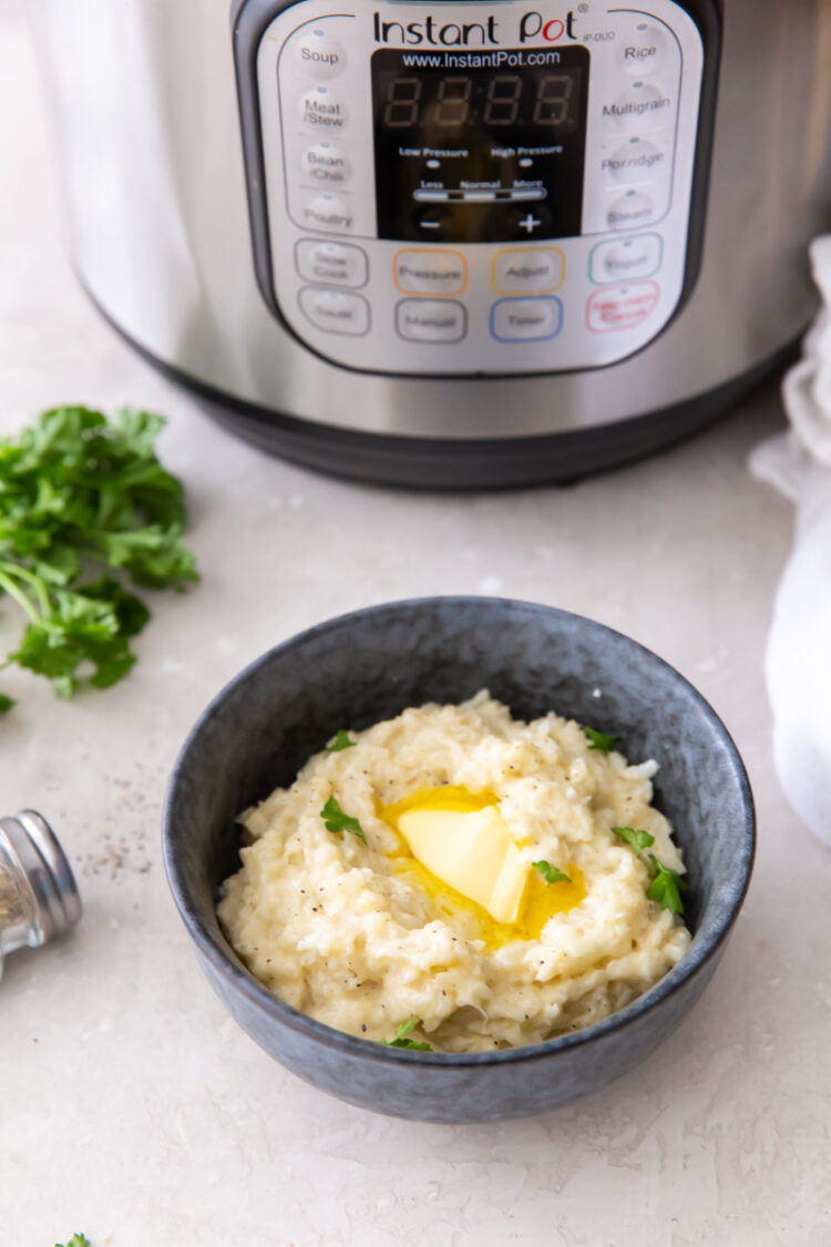 mashed cauliflower in a bowl with an instant pot in the background