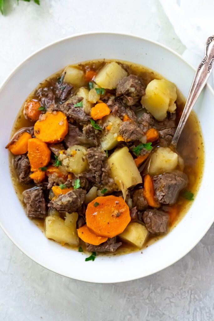 rump roast in a bowl with carrots and potatoes