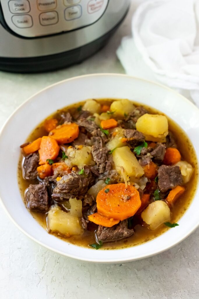 rump roast in a bowl with carrots and potatoes