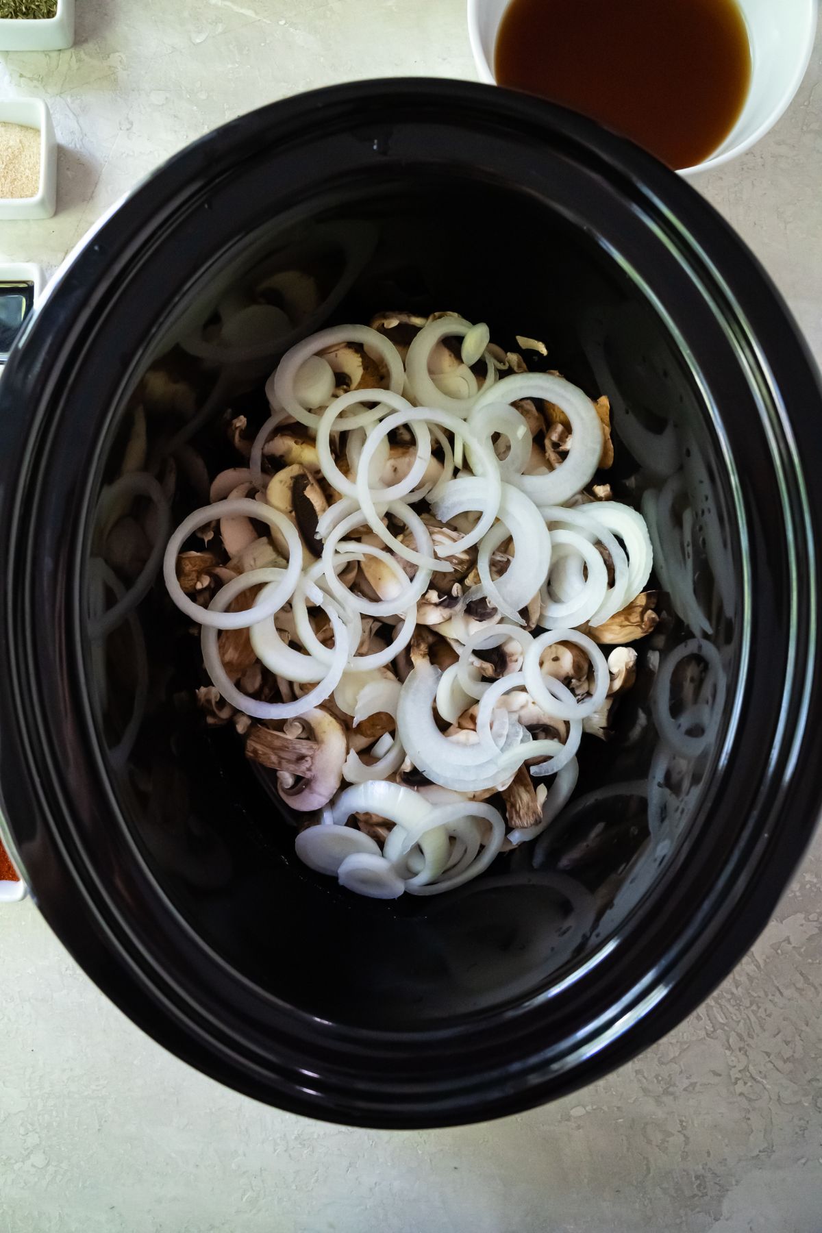 slice mushrooms and sliced onions in a crockpot