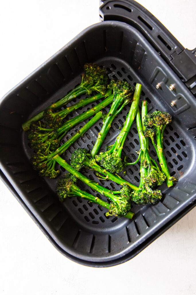 Cooked broccolini in an air fryer basket