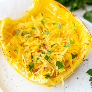 air fryer cooked spaghetti squash on a white plate with parsley and white napkin