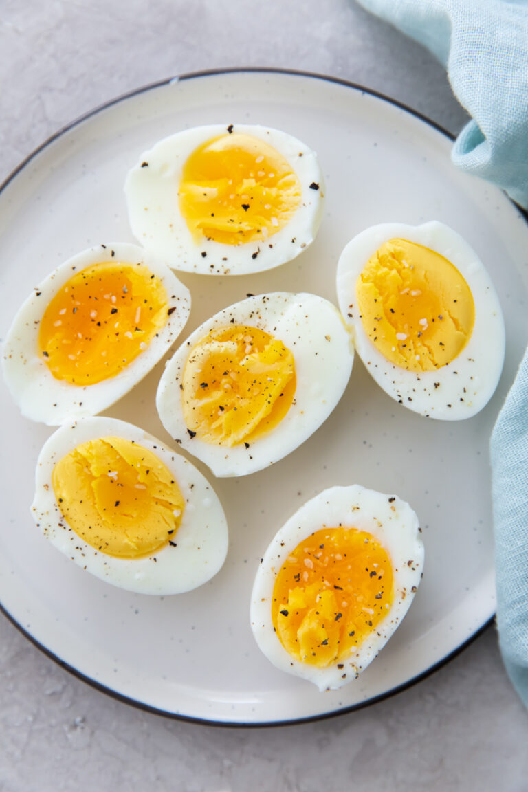 Pefected Air Frer Boiled Eggs with sallt and pepper on a white plate.