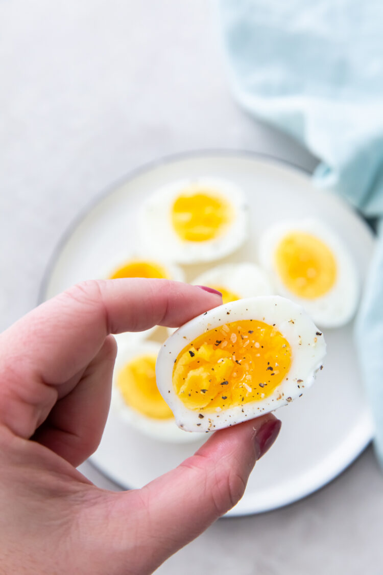 holding a hard boiled egg with salt and pepper