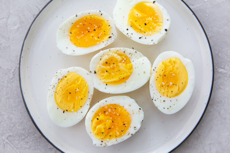 air fryer hard boiled eggs on a white plate with salt and pepper