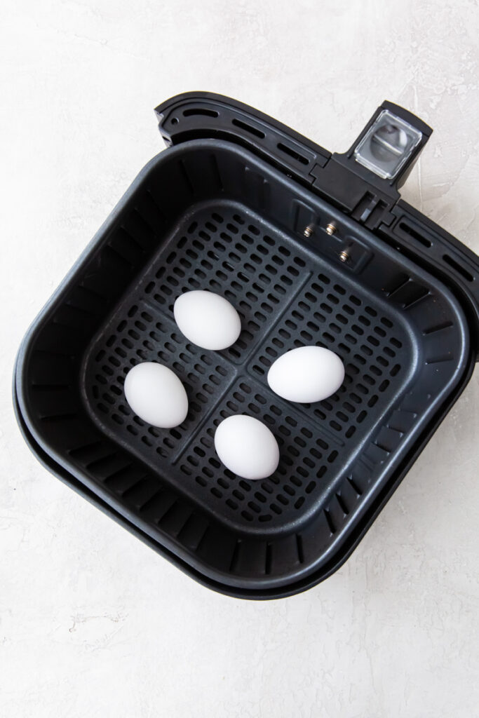 4 large eggs in an air fryer basket