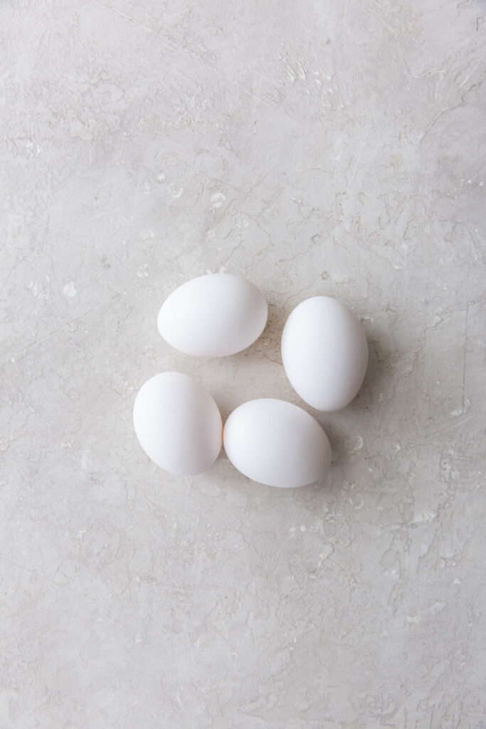 4 large eggs on a grey surface