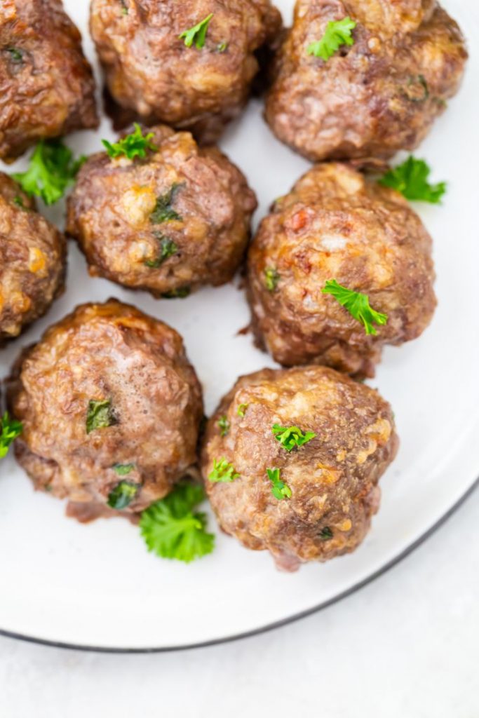 air fryer keto meatballs on a white plate with parsley