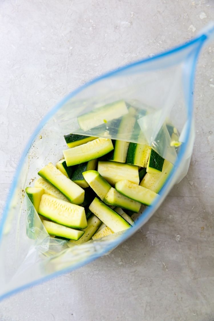 cut up zucchini in a bag with oil and seasoning