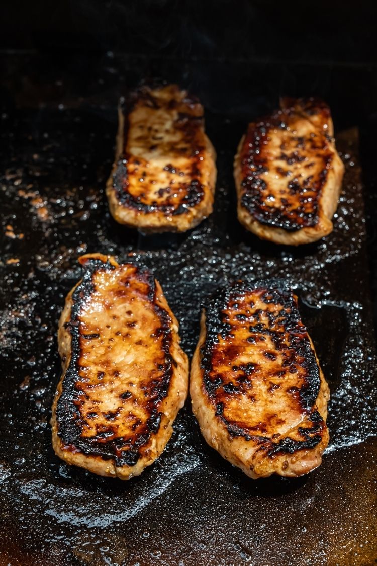 pork chops being cooked on a Blackstone Griddle 