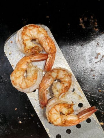 perfectly cooked blackstone shrimp on a spatula