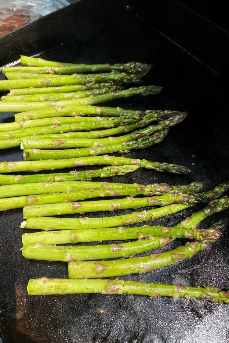 raw asparagus on a blackstone grill