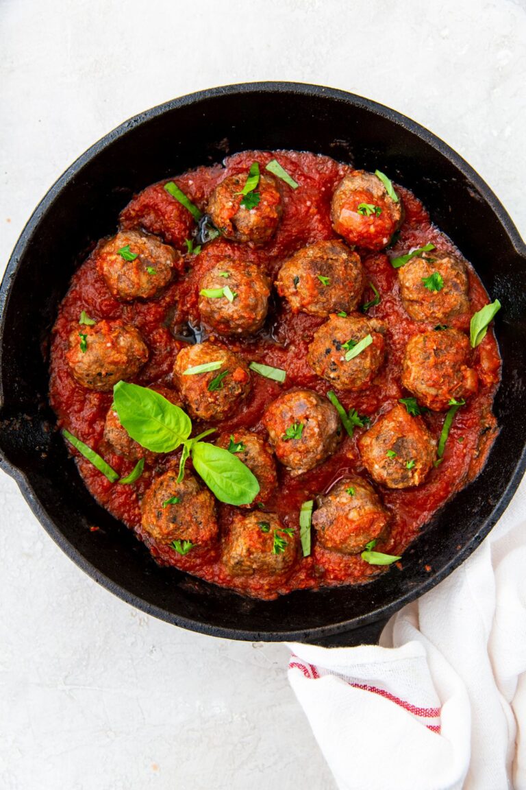 Easy Keto Cast Iron Meatballs in a cast iron skillet with basil.