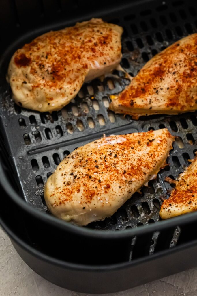 4 cooked 4 oz chicken breasts in an air fryer basket