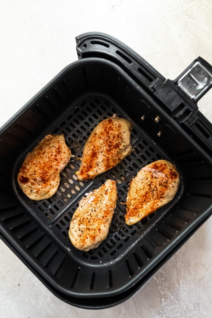 4 cooked 4 oz chicken breasts in an air fryer basket