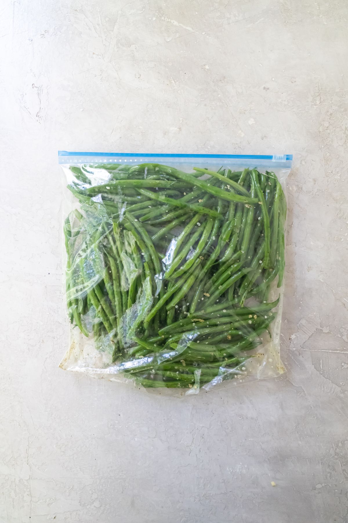 green beans in a large baggie with spices and oil