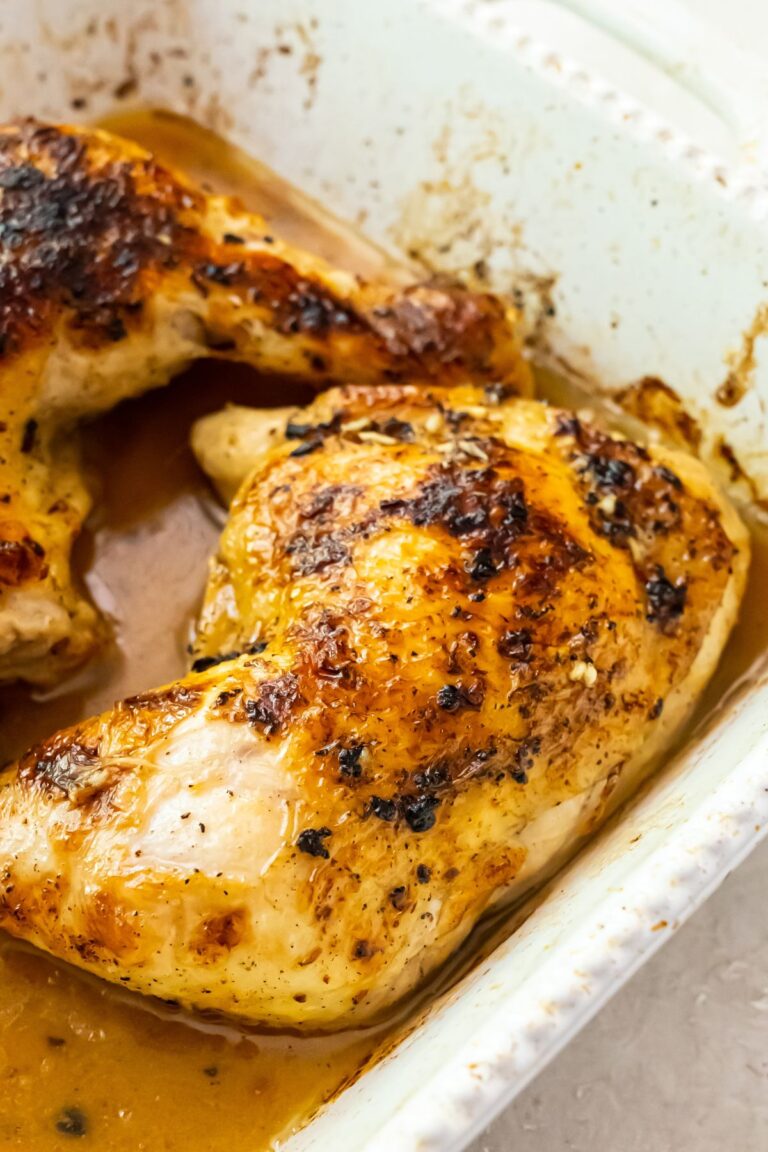 Easy Broiled Chicken Leg Quarters in a white casserole dish.