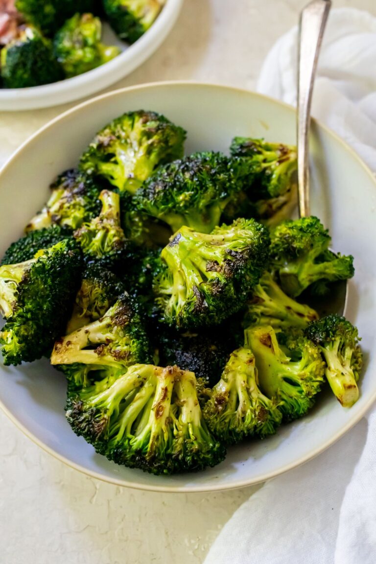 Easy Blackstone Broccoli Recipe in a white bowl with a spoon.