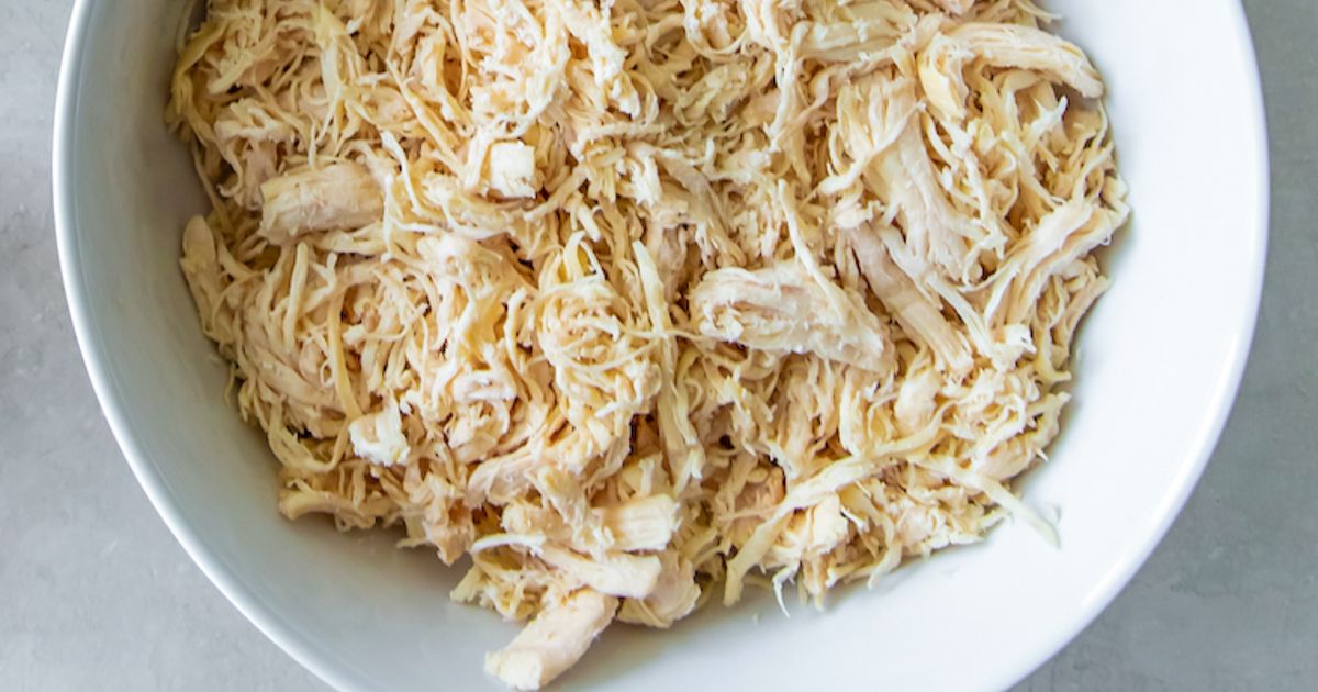 cooked shredded chicken breasts in a white bowl