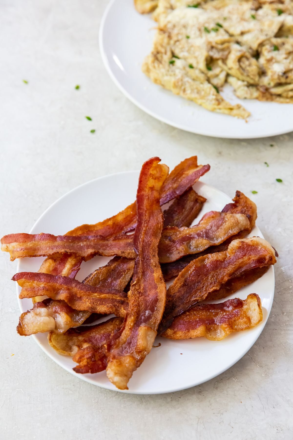 blackstone bacon on a white plate with scrambled eggs next to it