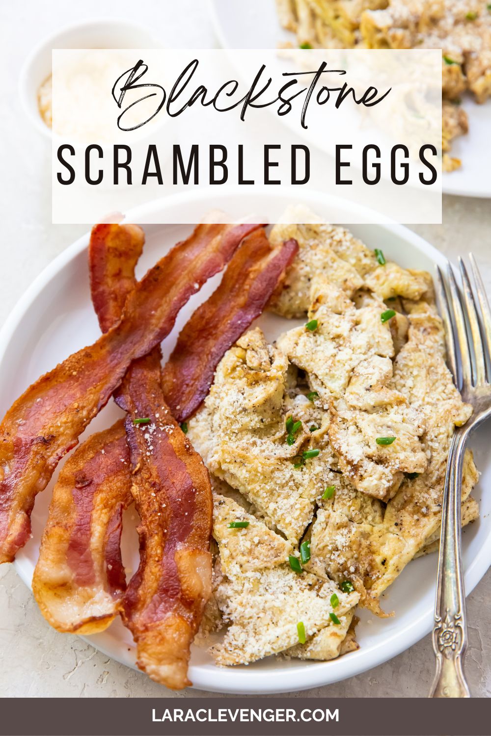 pin of scrambled eggs on white plate with bacon with a fork