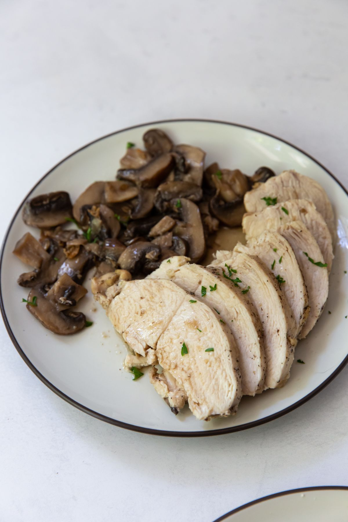 white plate with chicken and mushrooms on a plate