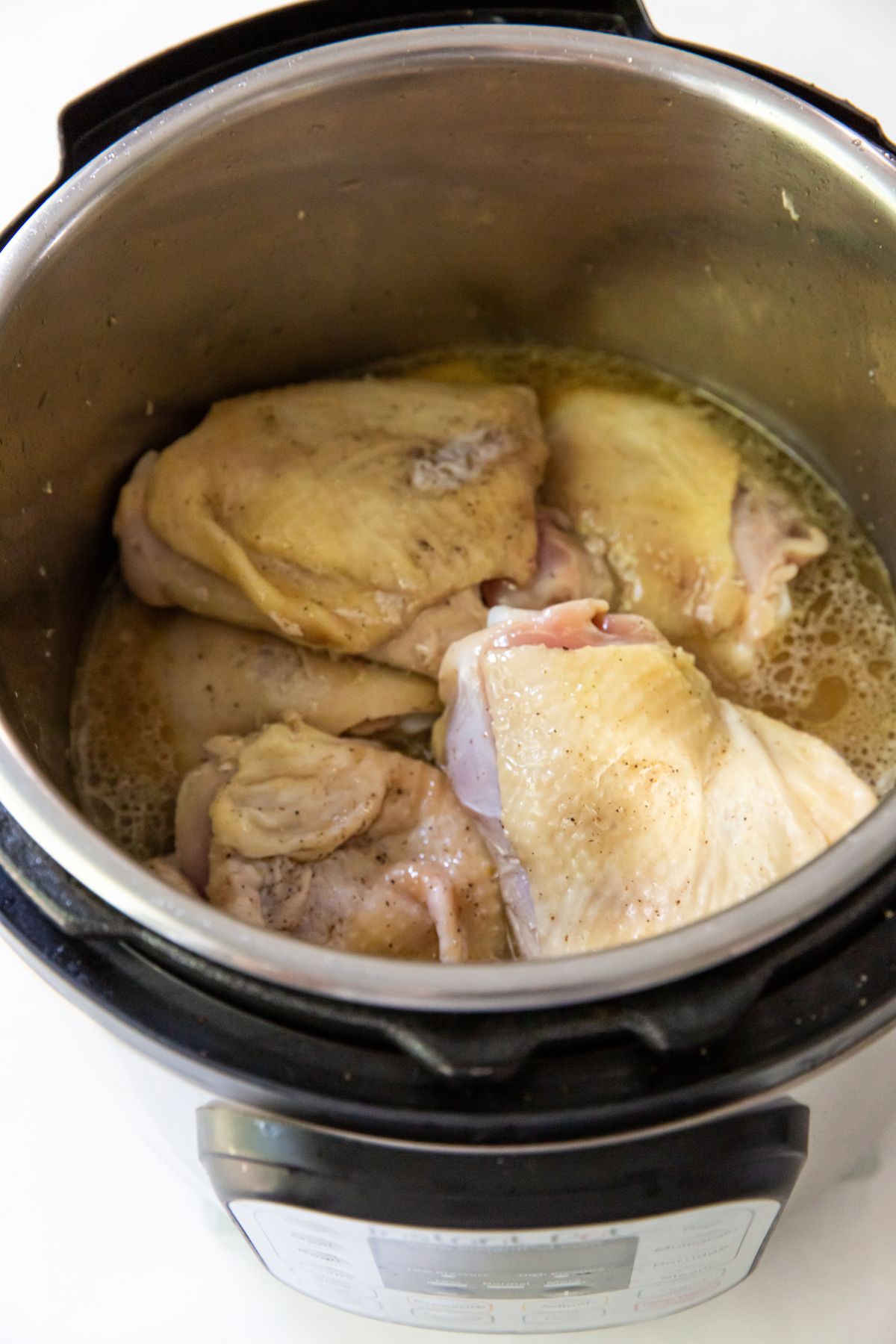 cooked chicken thighs with broth in the instant pot
