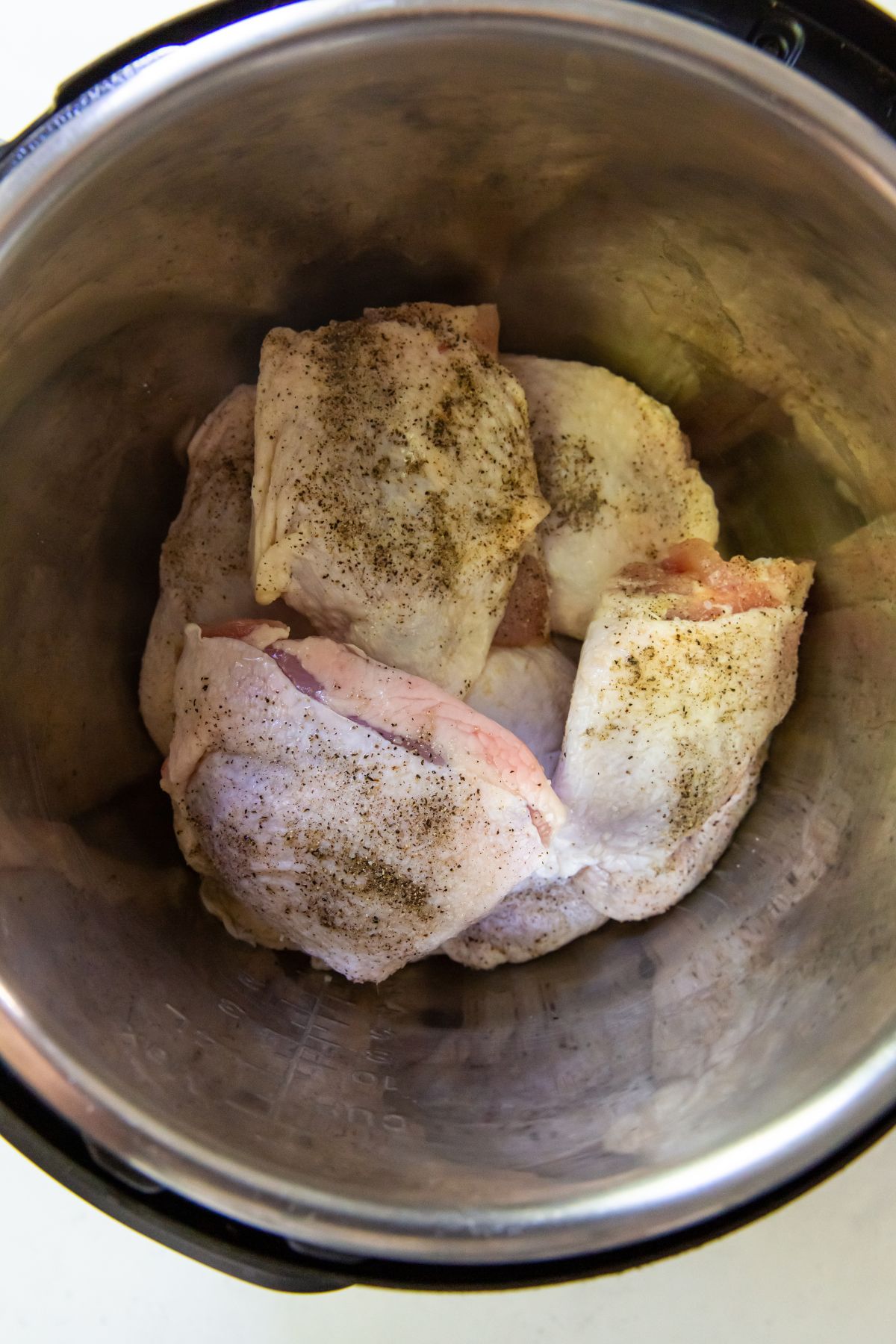 raw chicken thighs with seasoning in the instant pot