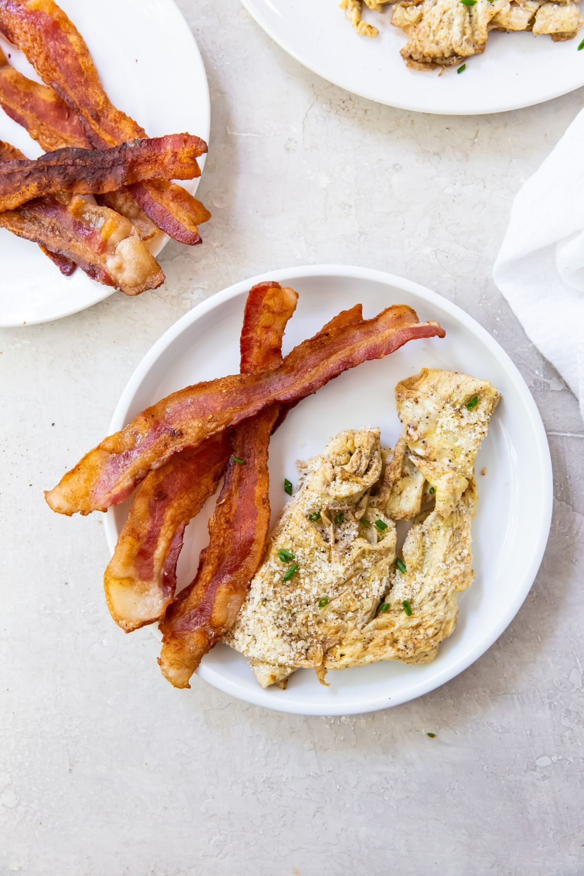 blackstone scrambled eggs on white plate with bacon