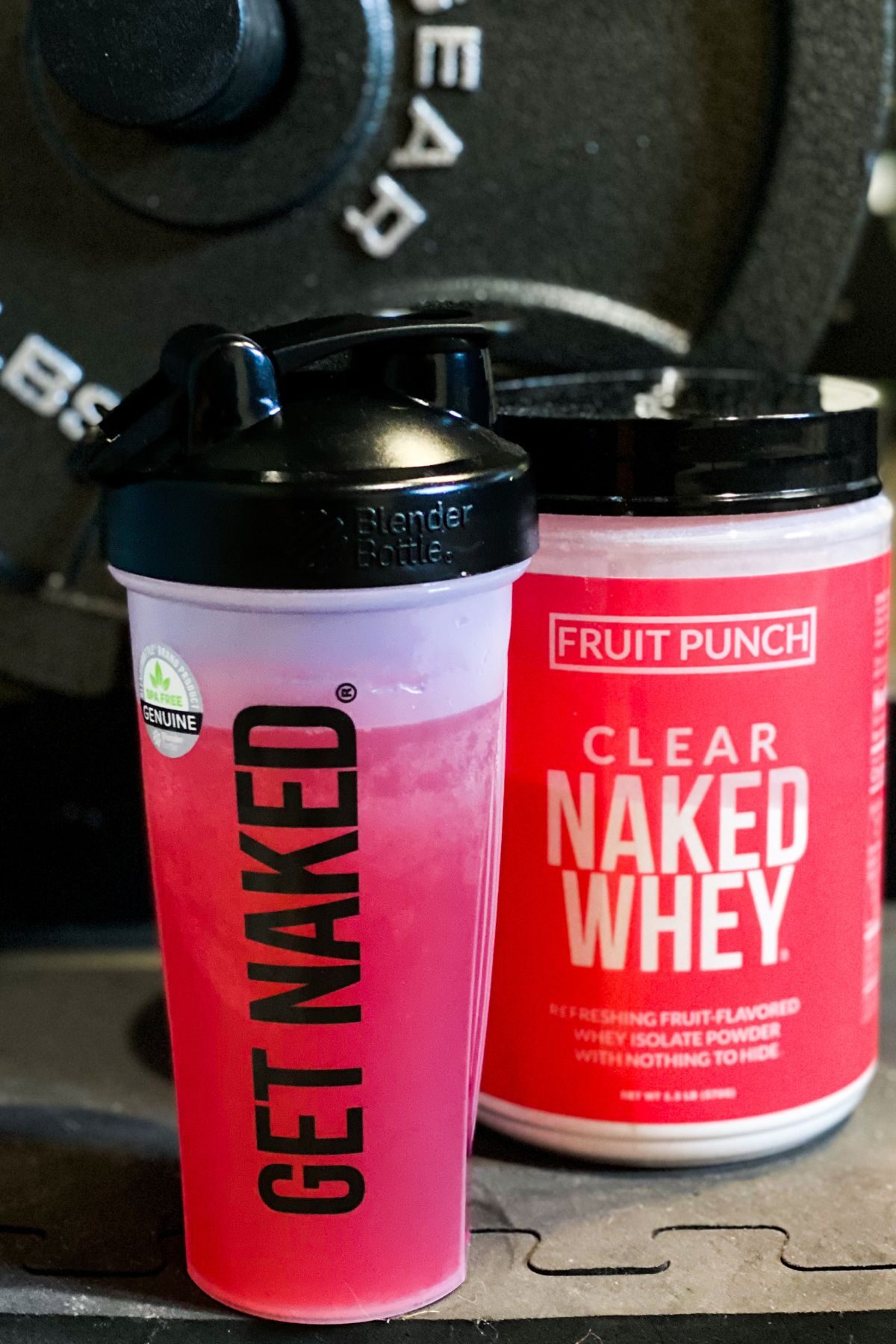 clear naked whey in a plastic water bottle next to a 45# weight