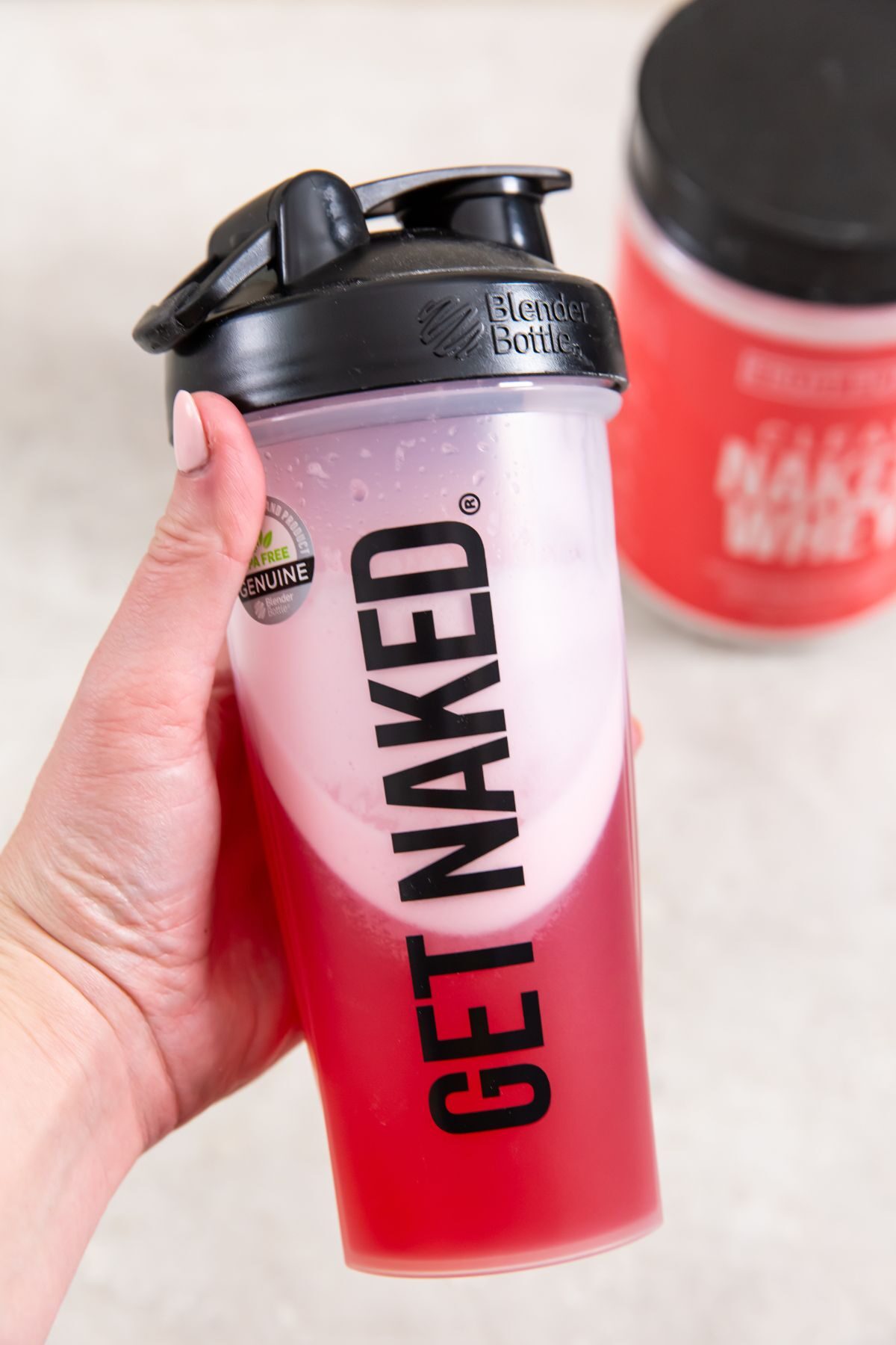 clear naked whey mixed with water and container in the background