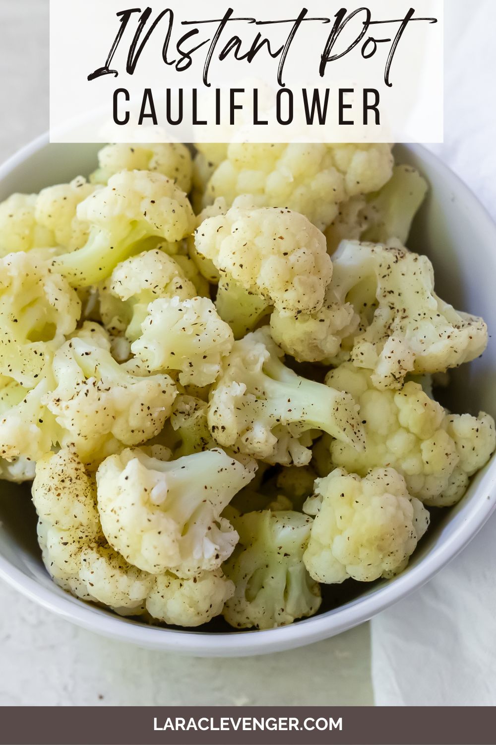 Pinable image of cauliflower sitting in a ceramic bowl on a white countertop