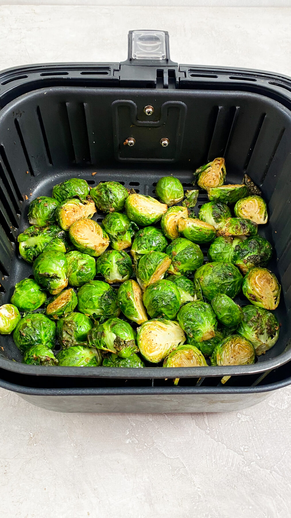 cooked brussel sprouts in an air fryer basket
