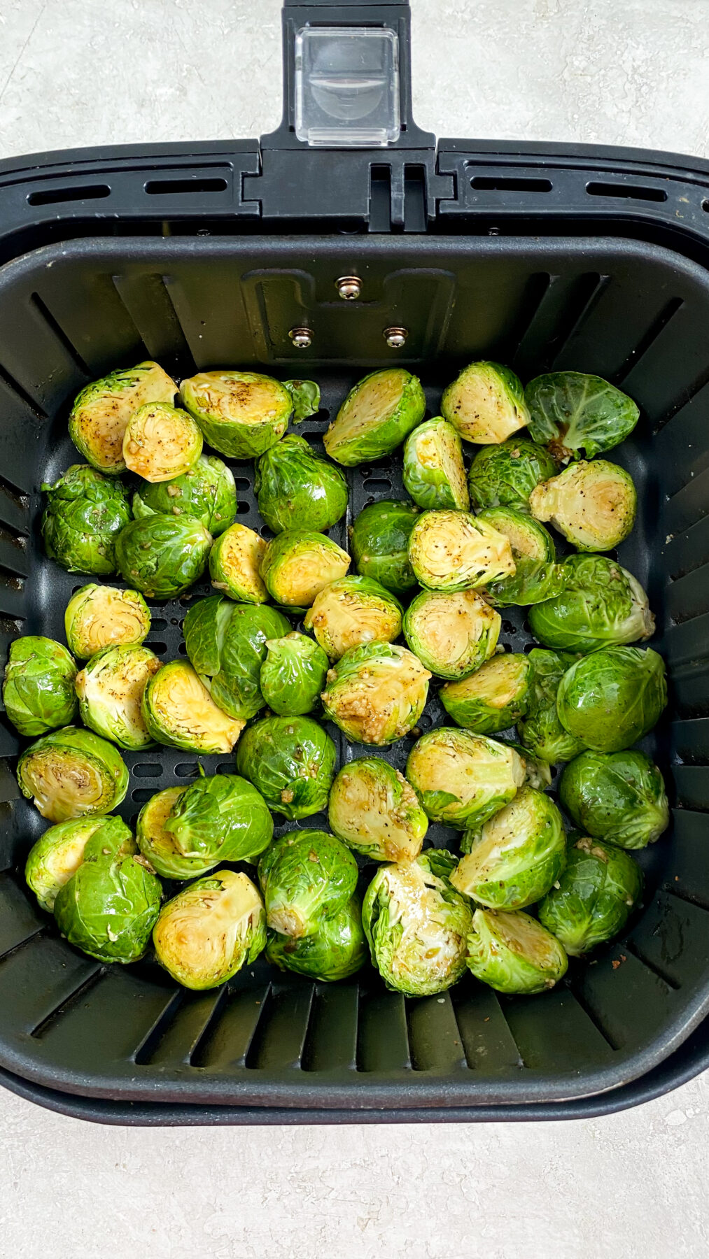 halved brussel sprouts in an air fryer basket