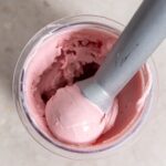 Ninja Creami Strawberry ice cream in a small white bowl with an ice cream scoop